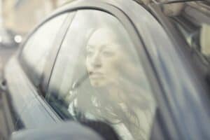 femme regardant fixement par la fenêtre d'une voiture